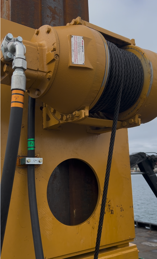 Close view of a hydraulic winch and hose installation